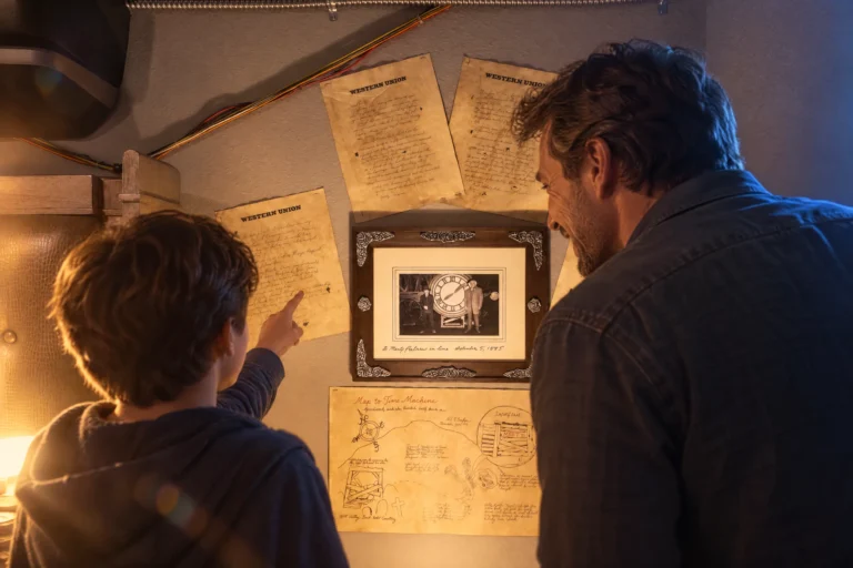 A dad and son study the letters and blueprints on the wall of Nap to the Future at Electronic Ice Castle