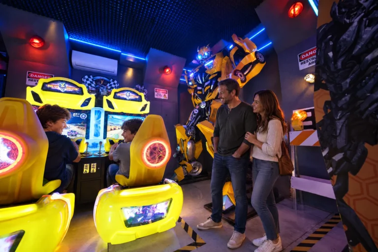 Two brothers race head to head on the driving games as their parents watch in the Robot Game Room at Electronic Ice Castle