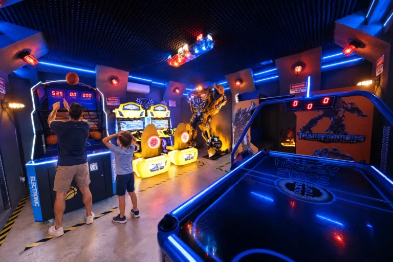 A dad shoots hoops while his son watches the scoreboard in the Robot Game Room at Electronic Ice Castle