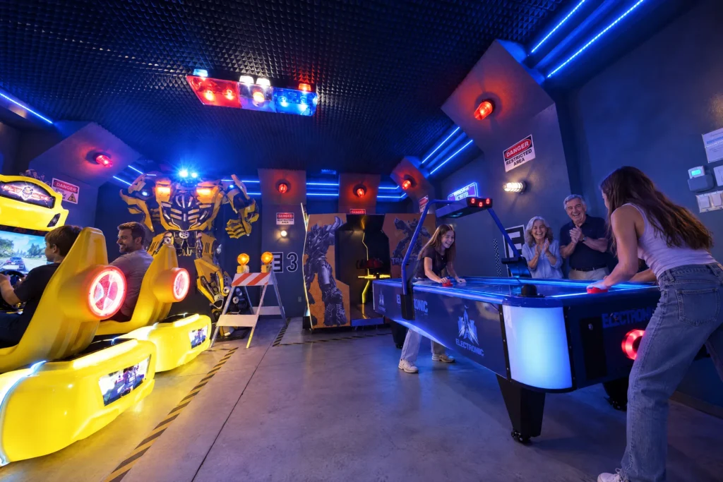 Teen sisters play air hockey as the grandparents cheer in the Robot Game Room at The Electronic Ice Castle