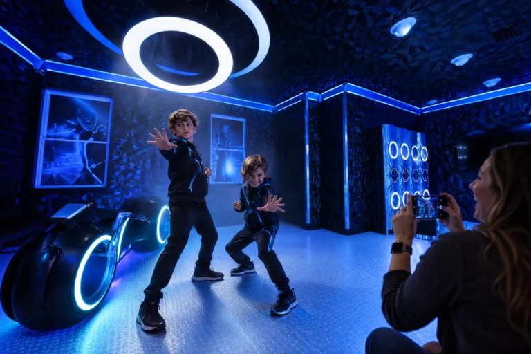 Two brothers strike hero poses while mom films them in The Grid "The Secret Suite" at Electronic Ice Castle