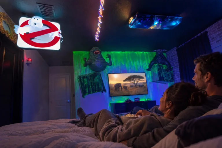 Parents share popcorn and a movie in bed in the Snoozebusters suite at Electronic Ice Castle